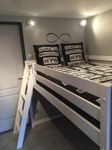 a bedroom with a white bed with pillows on it at Au Studi'Ô in Saint-Bonnet-en-Champsaur