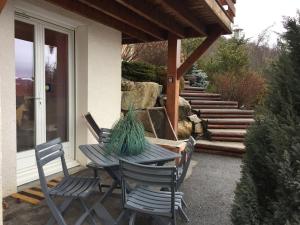 - une table et des chaises sur la terrasse couverte d'une maison dans l'établissement Au Studi'Ô, à Saint-Bonnet-en-Champsaur