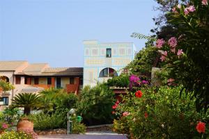 a building with a lot of flowers in front of it at Nicolaus Club Torre Moresca in Cala Liberotto