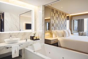 a bathroom with a bed and a sink and a mirror at El Embajador, a Royal Hideaway Hotel in Santo Domingo +40 photos
