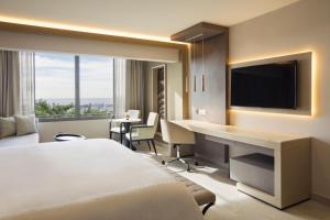 a hotel room with a bed and a desk with a television at El Embajador, a Royal Hideaway Hotel in Santo Domingo