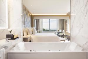 a bathroom with two beds and a tub in a room at El Embajador, a Royal Hideaway Hotel in Santo Domingo