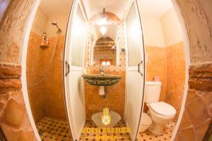 a bathroom with a sink and a toilet at Hotel Babylon Dades in Imdiazene