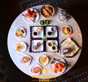 Hotel Babylon Dades في Imdiazene: طاولة مستديرة مع أطباق من الطعام عليها