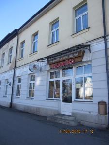 a white building with a sign for a restaurant at Iranija 21 in Daugavpils