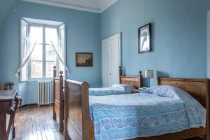 a blue bedroom with two beds and a window at Agriturismo Villa Gropella in Valenza