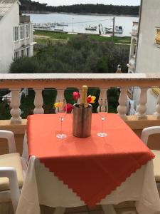 a table with two wine glasses on a balcony at Guest House Sandra in Rab