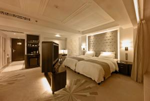 a large bedroom with a large bed and a television at Paramount Gallery Hotel in Shanghai