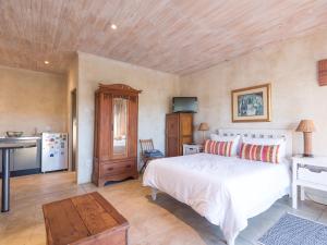 1 Schlafzimmer mit einem weißen Bett und einer Küche in der Unterkunft River Cottage in Kenton on Sea