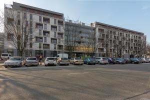 parking z samochodami zaparkowanymi przed budynkiem w obiekcie Millennium Awangarda Green w Warszawie