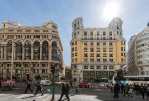マドリードにあるM&F ATTIC WITH GREAT VIEWSの建築物が並ぶ街道を横断する集団