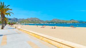 people on a beach with mountains in the background at Sa Marina / Sa Marina 7A in Alcudia
