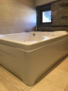 a white bath tub in a bathroom with a window at Veliko Tarnovo Villa Lora in Veliko Tŭrnovo
