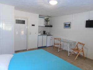Zimmer mit einem Bett und einem Tisch sowie einer Küche in der Unterkunft Ormos Drepanou Apartments in Lygia