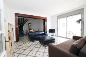 ein Wohnzimmer mit einem Sofa und einem Tisch in der Unterkunft La casa del Pi · La casa del Pi · House in the city, next to Barcelona and beach in Badalona