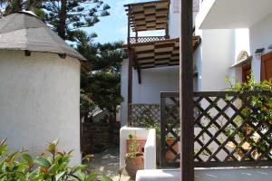 a white building with a fence and a chair at Axahas in Mési