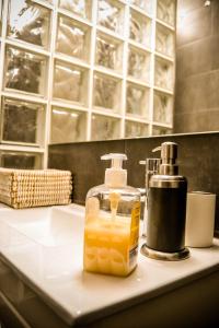 a bottle of soap sitting on a bathroom sink at Domvs Gaia GHouse B&B in Vila Nova de Gaia