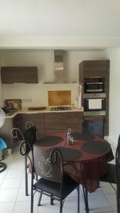 eine Küche mit einem Tisch und Stühlen im Zimmer in der Unterkunft Mers du Sud in Les Trois-Îlets