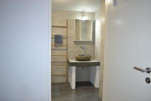 uma casa de banho com um lavatório e um espelho em Artemis Suites em Romanu