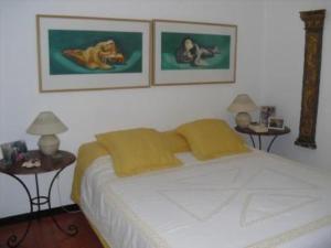 コスタ・ノヴァにあるCasa do Bico da Biaritzのベッドルーム1室(白い大型ベッド1台、テーブル2台付)