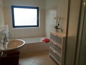 uma casa de banho com uma banheira, um lavatório e uma janela em Gästewohnung im Papenteich em Abbesbüttel