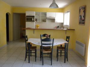 una sala da pranzo e una cucina con tavolo e sedie di Ecrin de verdure sur Le Lavandou - Classement Tourisme 3 Etoiles a Le Lavandou