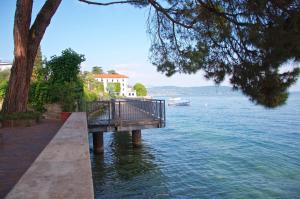 a wooden walkway next to the water with a house at Made in Brazil in Gardone Riviera