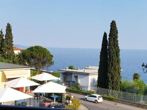 a street with umbrellas and a house and the ocean at Made in Brazil in Gardone Riviera