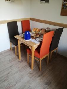 a wooden table with chairs and a plate of food on it at Frühstückspension Sterr in Strebersdorf