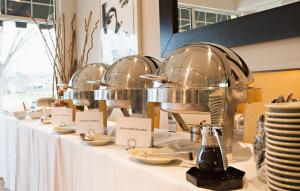 una fila de mesas con platos y platos. en Hotel Rehoboth, en Rehoboth Beach