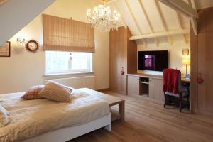 
a bedroom with a bed and a tv at B&B Villa Sans Soucis in Nieuwpoort
