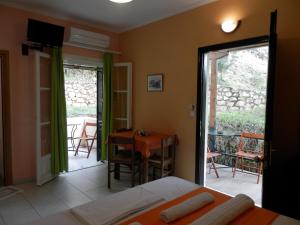 a bedroom with a bed and a table and chairs at Green Villa in Agios Nikitas