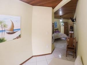 a living room with a painting of a sailboat on the wall at Pousada Recanto do Sabiá in Abraão