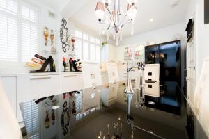Habitación con armarios blancos y lámpara de araña. en Juzz Holiday Lets, en Londres