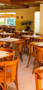 un restaurante con mesas y sillas de madera y una cafetería en Apto Parque do China, en Domingos Martins
