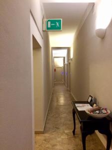 a hallway with a sign on the wall and a table at Residence Ducale in Rodi Garganico