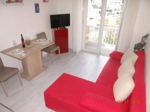 sala de estar con sofá rojo y mesa en B&B Buzolic, en Hvar