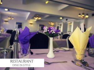 una mesa con flores púrpuras en jarrones. en The Royal Boston Hotel, en Blackpool