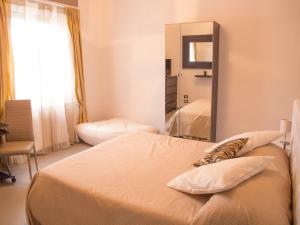 1 dormitorio con 1 cama grande y espejo en B&B Ricci en Livorno