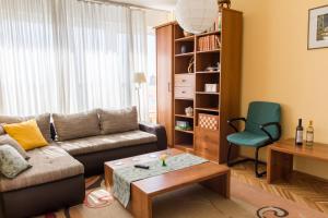 een woonkamer met een bank en een stoel bij Sunny Apartment in Belgrado