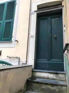 une porte verte sur le côté d'un bâtiment dans l'établissement Appartamento via Roma 56, à Monterosso al Mare