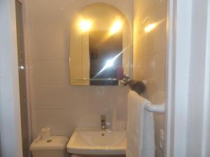 a bathroom with a sink and a mirror and a toilet at Casa do Largo in Porto