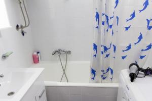 a bathroom with a white tub and a shower curtain at Sunny Apartment in Belgrade +10 photos