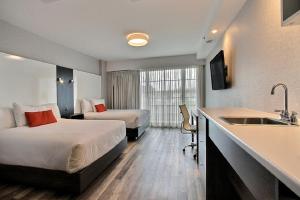 a hotel room with two beds and a sink at Hotel Classique in Quebec City