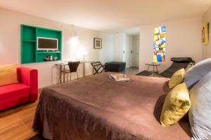 a bedroom with a large bed and a red couch at Hotel le Corbusier in Marseille