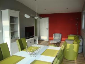 a living room with a table and green chairs at Exklusives Ferienhaus keine Monteure in Lichtenau