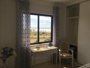 a bedroom with a desk and a window with a view at Paradise in Costa da Caparica