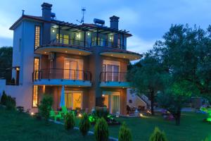 a large house with a lit up facade at Excellent Villa in Vourvourou