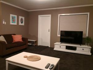 a living room with a flat screen tv and a couch at Driftwood Villa in Kaikoura