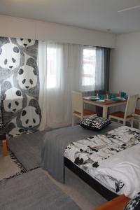 Hautakylä的住宿－Visit Hautakylä，一间卧室配有一张床,墙上挂着熊猫